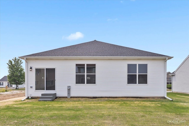 rear view of house featuring a yard