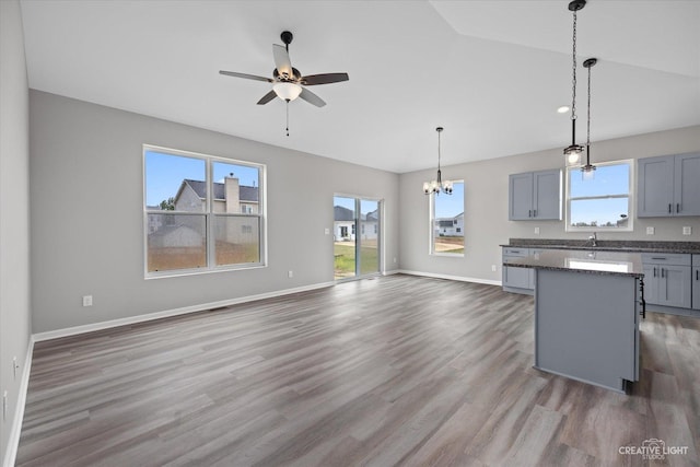 kitchen with gray cabinetry, dark hardwood / wood-style flooring, decorative light fixtures, and ceiling fan with notable chandelier