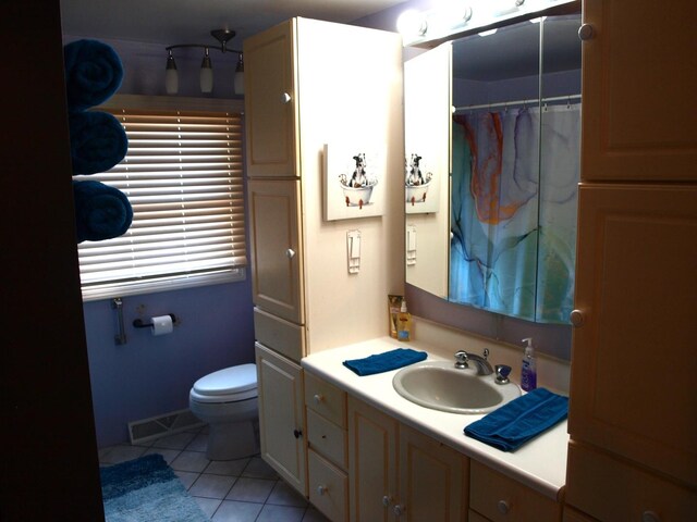 bathroom with toilet, tile patterned flooring, and vanity