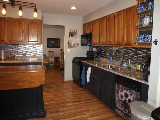 kitchen featuring sink, tasteful backsplash, black appliances, and light stone countertops