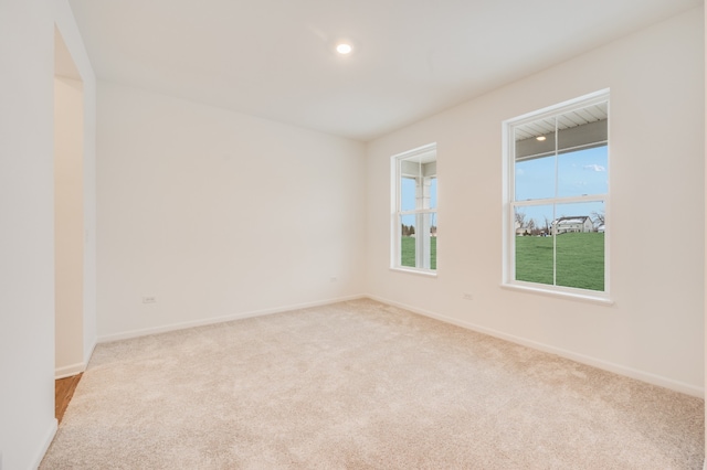 unfurnished room featuring light carpet and a wealth of natural light