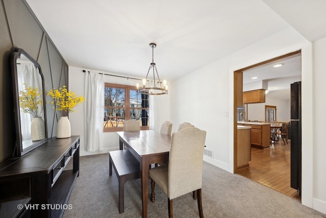 dining space with carpet floors and a notable chandelier