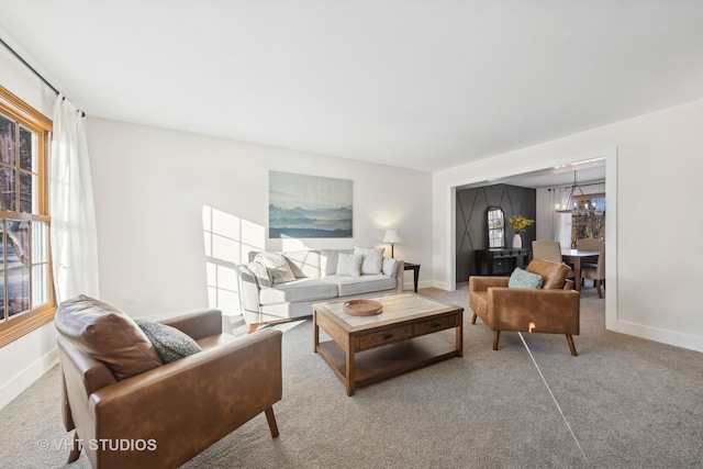 carpeted living room featuring a chandelier