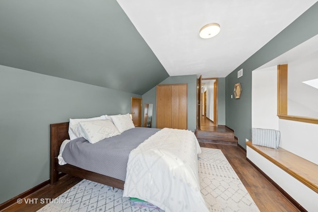 bedroom with lofted ceiling and dark hardwood / wood-style floors