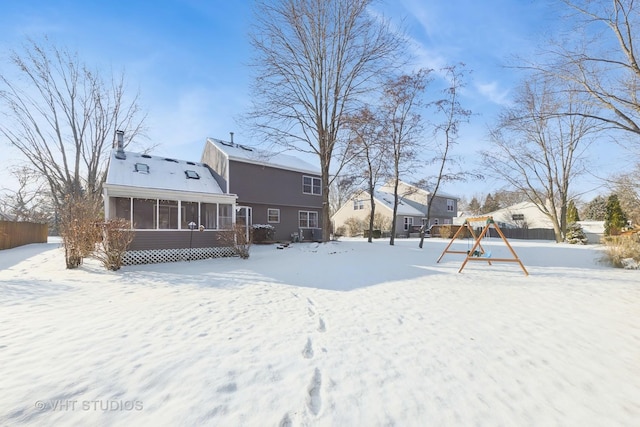 snow covered property featuring a sunroom