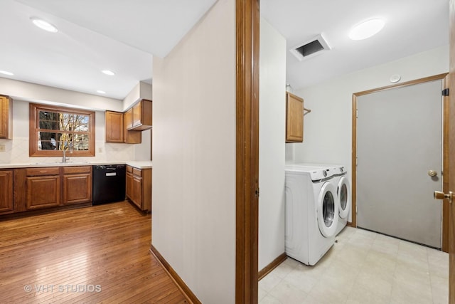 washroom with sink, light hardwood / wood-style flooring, and independent washer and dryer