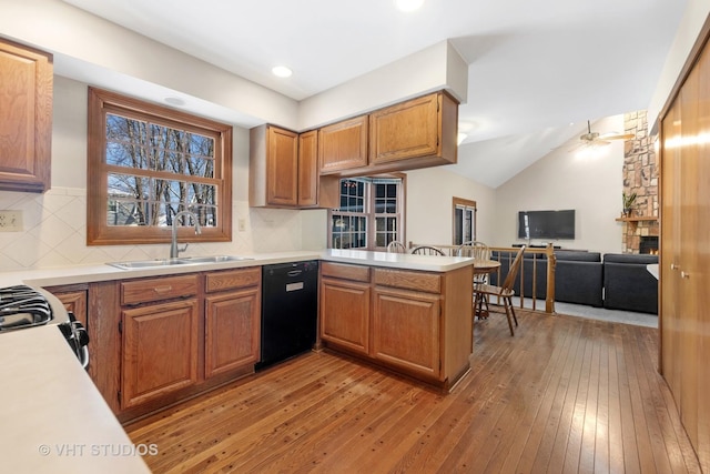 kitchen featuring dishwasher, kitchen peninsula, ceiling fan, sink, and light hardwood / wood-style flooring