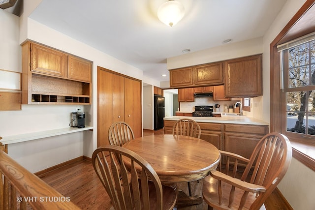 kitchen with sink, black appliances, and dark hardwood / wood-style floors