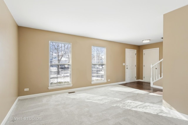 carpeted spare room featuring a wealth of natural light