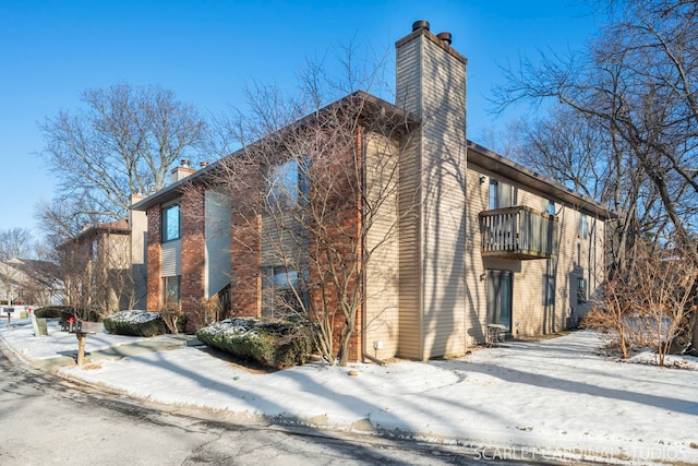 snow covered property with a balcony