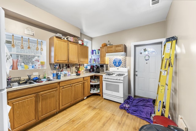 kitchen featuring sink, light hardwood / wood-style floors, and white range with gas cooktop