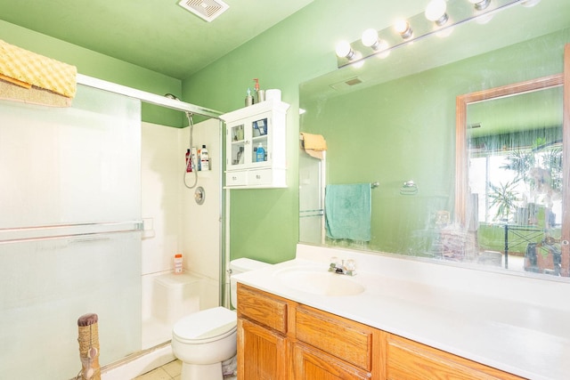 bathroom featuring a shower with door, vanity, and toilet