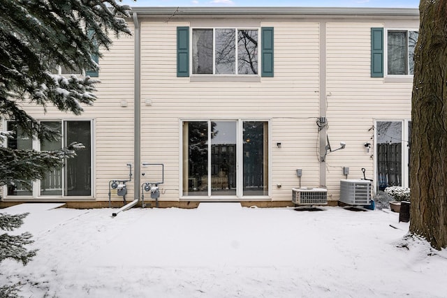 snow covered rear of property with cooling unit