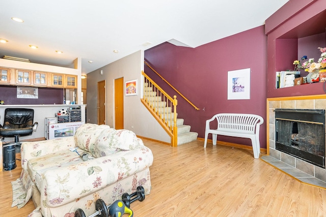 living room with a tile fireplace and wood-type flooring