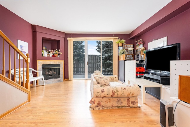 living room with a tile fireplace and hardwood / wood-style floors