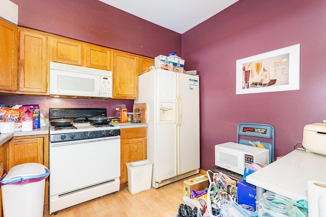 kitchen featuring white appliances and light hardwood / wood-style flooring