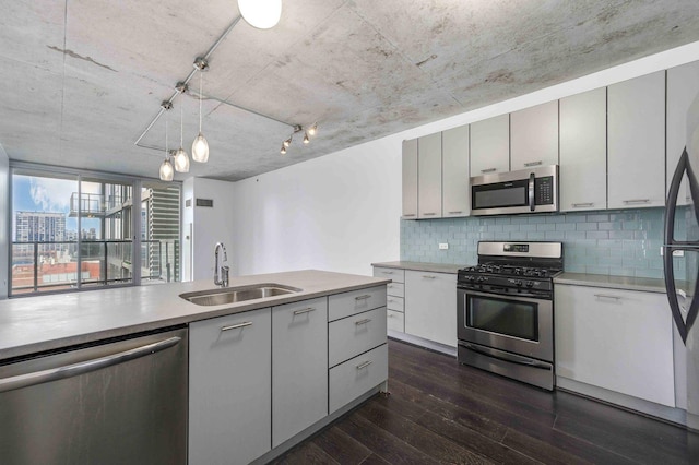 kitchen featuring appliances with stainless steel finishes, dark wood-style flooring, a sink, and light countertops