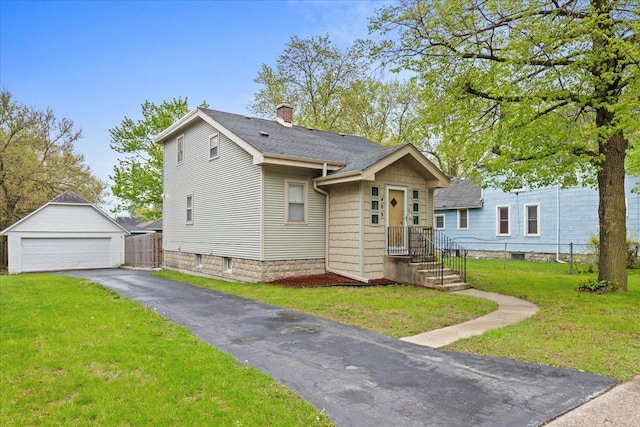 view of front of property featuring a garage, a chimney, an outbuilding, and a shingled roof