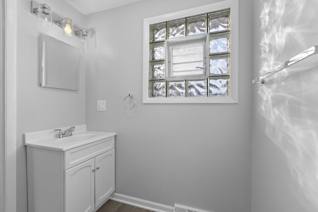 bathroom with vanity, baseboards, and wood finished floors