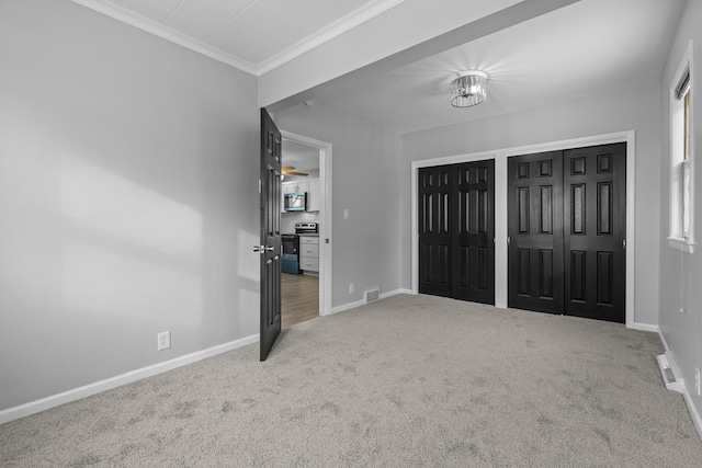 interior space with carpet flooring, multiple closets, and crown molding