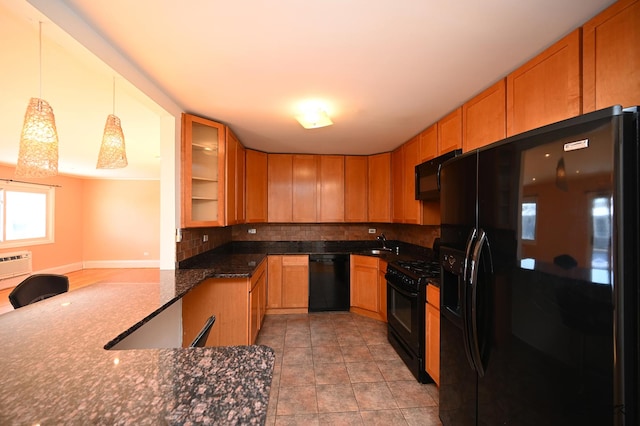 kitchen featuring sink, decorative light fixtures, dark stone countertops, backsplash, and black appliances