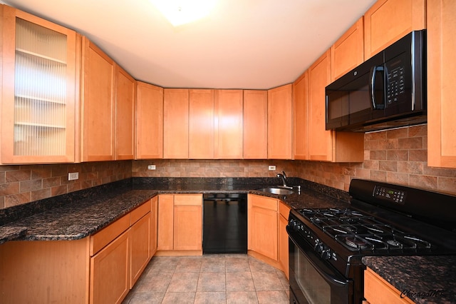 kitchen featuring dark stone countertops, black appliances, light tile patterned floors, light brown cabinets, and sink