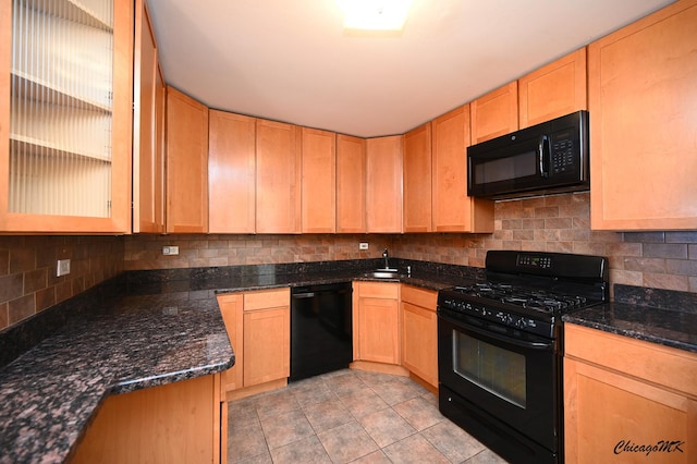 kitchen featuring light tile patterned floors, black appliances, backsplash, dark stone countertops, and sink