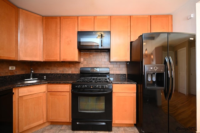 kitchen featuring dark stone countertops, black appliances, tasteful backsplash, and sink