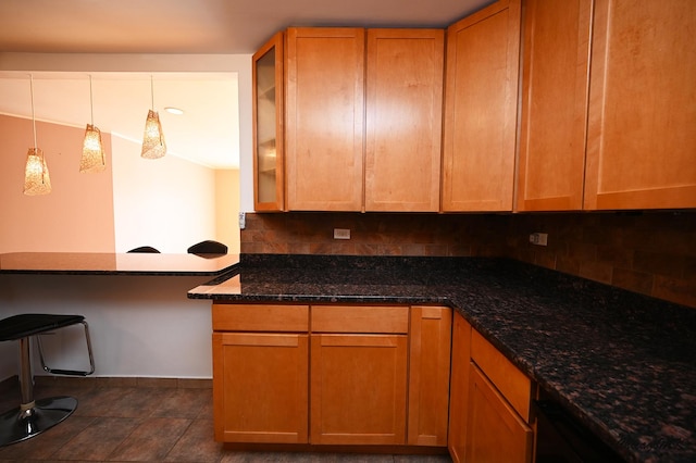 kitchen featuring hanging light fixtures, dark stone countertops, and tasteful backsplash