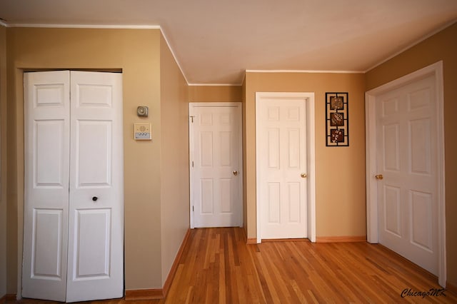 unfurnished bedroom with multiple closets, light hardwood / wood-style flooring, and crown molding