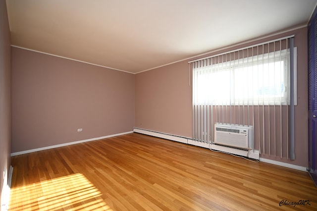 empty room with hardwood / wood-style flooring, an AC wall unit, and a baseboard heating unit