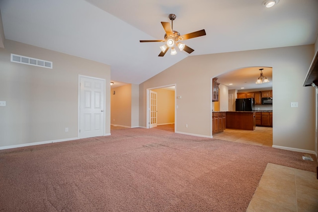 unfurnished living room with vaulted ceiling, light colored carpet, and ceiling fan