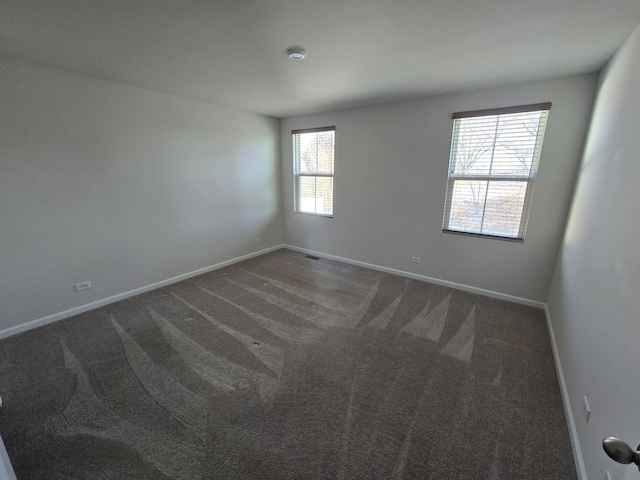 empty room featuring dark colored carpet