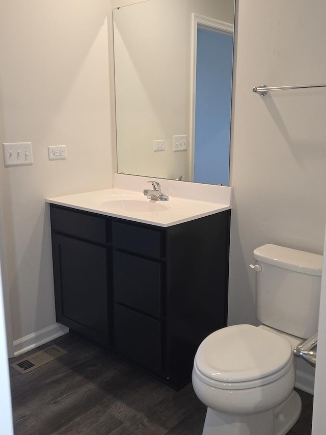 bathroom featuring toilet, vanity, and hardwood / wood-style flooring