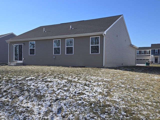 view of snow covered rear of property