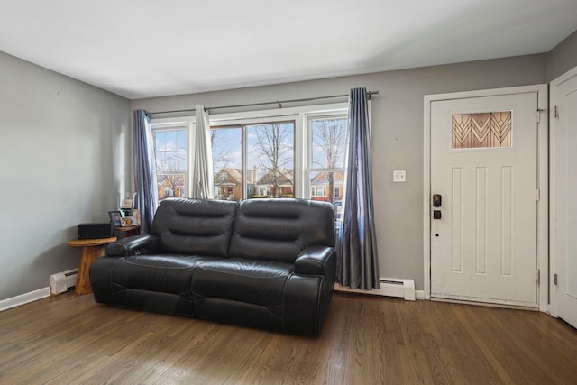 living room with a baseboard heating unit and dark hardwood / wood-style floors