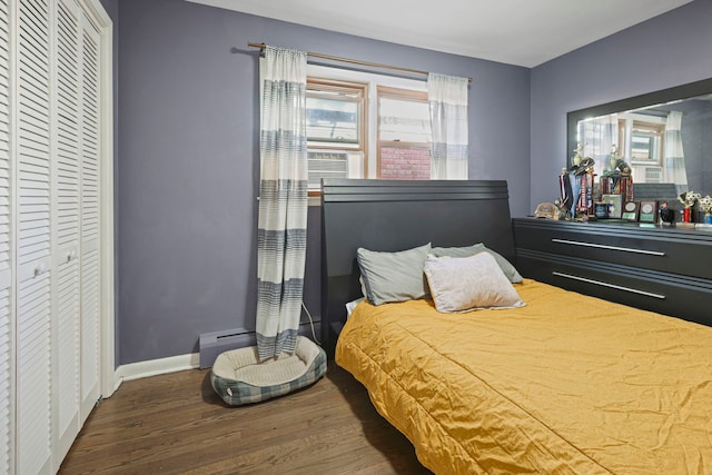 bedroom with baseboard heating, dark hardwood / wood-style flooring, and cooling unit