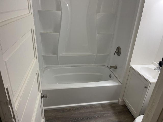 bathroom with hardwood / wood-style flooring, bathing tub / shower combination, and vanity