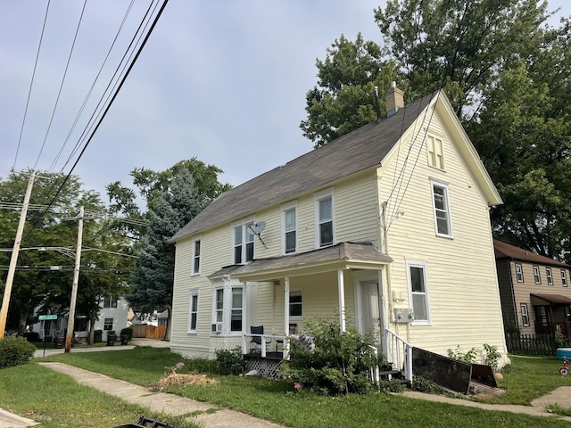 view of front of house featuring covered porch and a front lawn