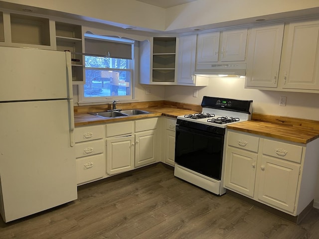 kitchen with range with gas stovetop, wood counters, white refrigerator, sink, and white cabinetry