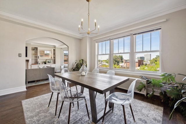 dining space featuring built in shelves, dark hardwood / wood-style flooring, crown molding, and a chandelier