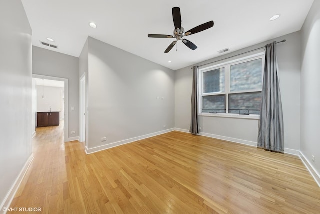 empty room featuring ceiling fan and light hardwood / wood-style flooring