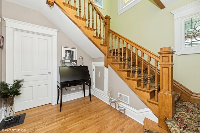 stairs featuring a healthy amount of sunlight and wood-type flooring