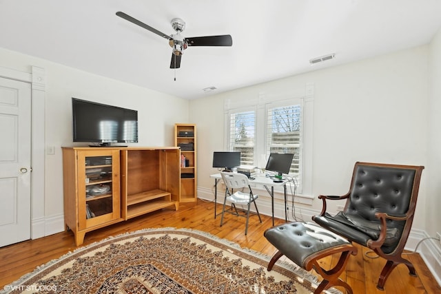 living area featuring wood-type flooring and ceiling fan