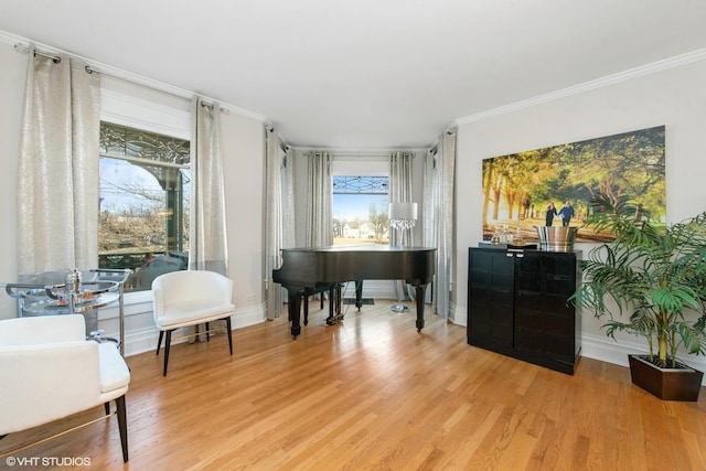 miscellaneous room with ornamental molding and light hardwood / wood-style flooring