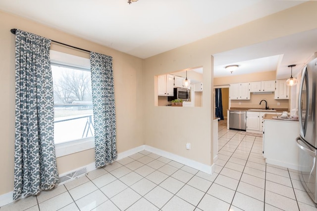 kitchen with sink, white cabinetry, stainless steel appliances, and a wealth of natural light