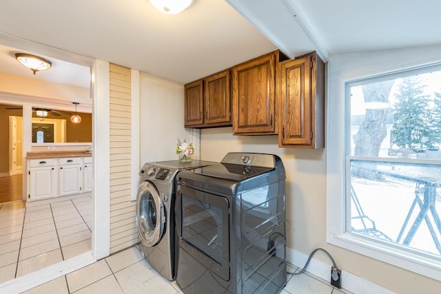 washroom with washer and dryer, light tile patterned flooring, and cabinets