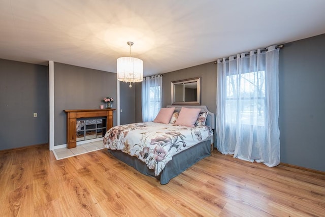 bedroom with an inviting chandelier and light wood-type flooring