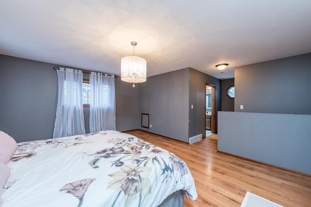 bedroom featuring light wood-type flooring and a notable chandelier