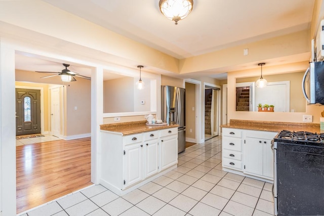 kitchen with ceiling fan, light tile patterned floors, white cabinets, and stainless steel appliances